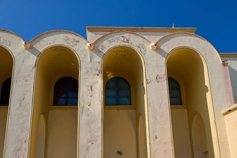 Primary school, Beige-coloured façade with arched windows against a clear sky, Armando Bernabiti,