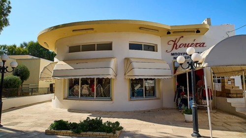 A building with a round façade and large shop windows, sun protection marked, Armando Bernabiti,