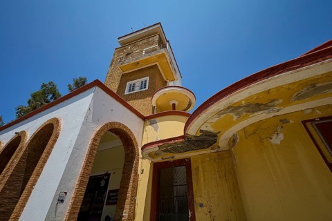 Market Hall, Agora, Historical building with vaulted arches and aged walls under a bright sky,