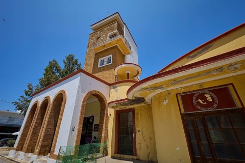 Covered market, agora, building with clock tower, characterised by red and yellow details, robust