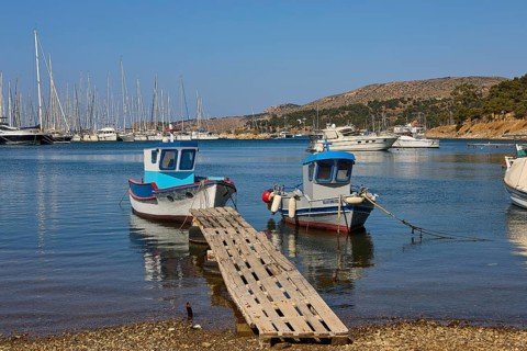 Two small boats on a wooden jetty in a quiet harbour with sailing yachts, Lakki, Leros, Dodecanese,