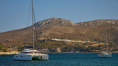 Two sailing boats on a calm sea, with barren hills in the background, Lakki, Leros, Dodecanese,