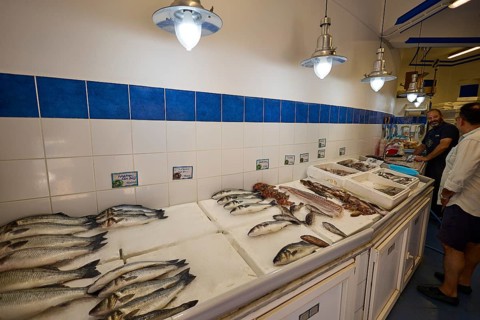 Fresh fish on ice in a shop with blue and white tiles and lamps, Lakki, Leros, Dodecanese, Greek