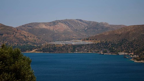 Landscape with mountains behind a blue sea under a clear blue sky, refugee shelter, Lakki, Leros,
