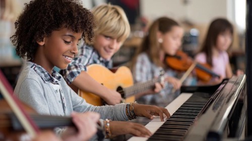 Diverse children paying musical instrument and learning music at music school, AI generated
