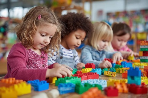 Children developing creativity while playing painting and drawing games at the table at daycare
