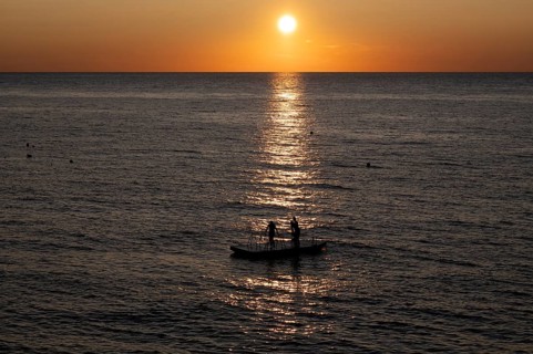 Children playing on bathing island, bathing raft, swimming island, Étretat, sea, sunset, evening