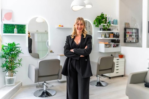 Portrait of a successful female business owner posing proudly in her modern hair and beauty salon,