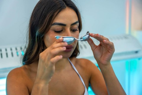 Client preparing for a uv tanning session, holding protective eyewear while getting ready in a