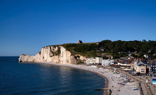 Rock arch Falaise or Porte d'Amont, beach, behind it monument in honour of the French aviators