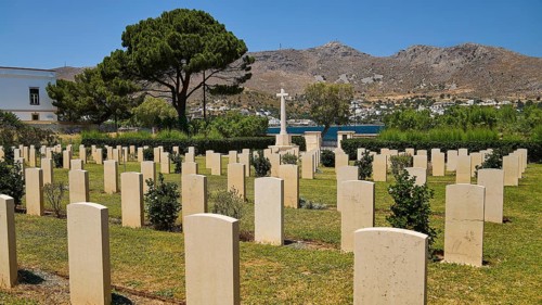 Cemetery with gravestones and view of mountains and sea, overgrown with trees, Military Cemetery,