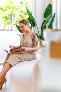 Young woman reading a magazine while waiting in a beauty salon, enjoying the relaxing atmosphere