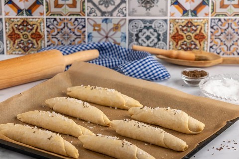 Sprinkle the raw salt sticks with salt and caraway seeds on a baking tray