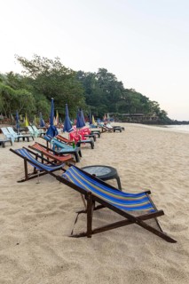 Abandoned deckchairs and parasol after sunset at Charlie Beach, Koh Mook Island, Andaman Sea,