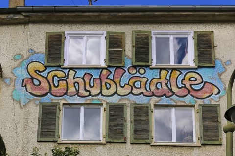 Clothes shop and meeting café Schublädle, mural, house facade, writing, social project, second-hand
