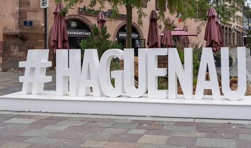 Large lettering in an urban setting with cafés in the background and autumnal flair, Haguenau,
