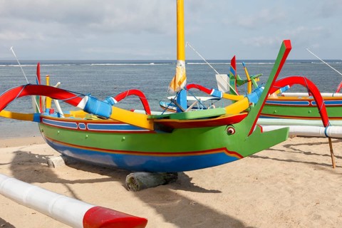 Colourfully painted fishing outriggers on Sanur beach, Bali, Indonesia
