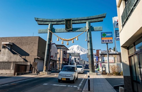 Cars drive through the city, Grand Torii Gate across a street, street scene, Mt. Fuji, Fujiyoshida,