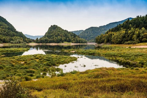 Picturesque mountain lake with water reflections in autumn, Lac de Kruth-Wildenstein, Kruth,