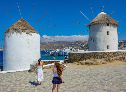 Mykonos, Cyclades, Greece - Tourists photograph the six sixteenth-century windmills lined up on a