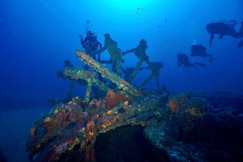 Divers explore a paddle wheel covered with sea sponges in the Mediterranean near Hyères, Wreck
