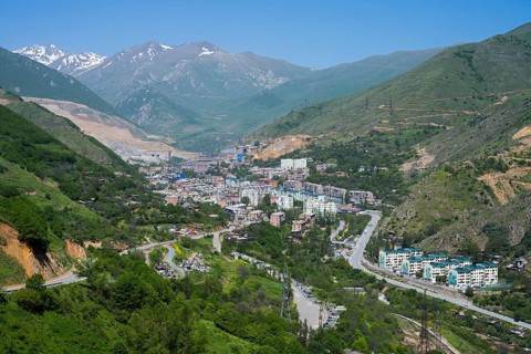 View of a city in a valley surrounded by mountains and green landscapes, view of Qajaran, Kajaran