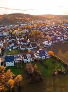 Near settlement with autumn trees and roofs, illuminated by golden sunlight, Aidlingen, Böblingen
