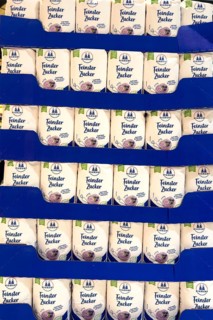 Many large quantities of stacked sugar packets on sale by retailers at retailers, Germany