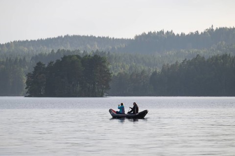 Paddler, lake surrounded by forest, near Sunne, Sweden