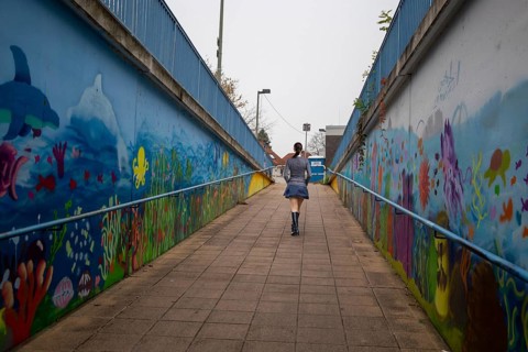 (Photo montage) Young woman at the end of a dark underpass