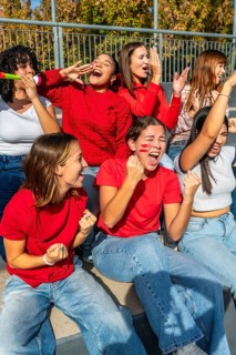 Group of diverse young women showing enthusiasm and support while attending a sports event,
