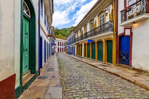 Street with old colonial-style houses and sunlit cobblestones in the historic city of Ouro Preto in