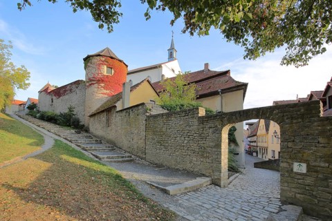 Historic city wall with wall tower, city fortification, archway, autumn colors, stairs, bridge