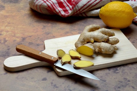 Ginger, ginger root cut with ginger slices on wooden boards