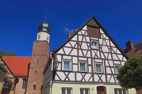 Half-timbered house and tower of the Catholic Church, town of Heideck in the district of Roth,