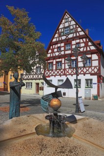Half-timbered houses and fountain figure flute player, on Rathausplatz, city of Heideck in the