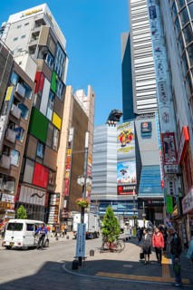Street scene with skyscrapers, figure Godzilla head on a skyscraper, Shinjuku City, Tokyo, Japan