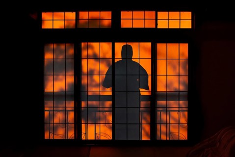 Shadows of a man in kimono, on the balcony behind sliding shoji doors in a traditional Japanese