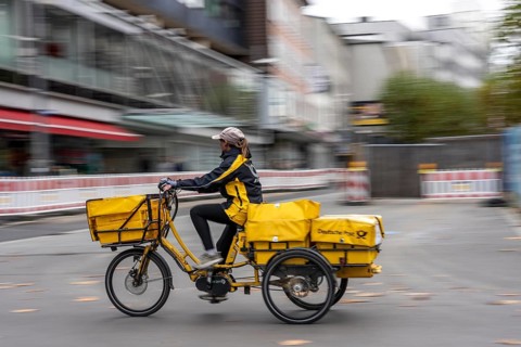 Delivery agent, Deutsche Post mailman on e-bike, Bochum, North Rhine-Westphalia, Germany