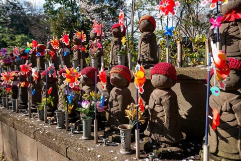Jizo statues with red crocheted caps, guardian deities for deceased children, Unborn Children