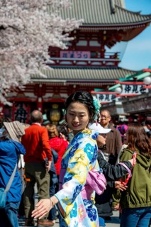 Young Japanese woman wearing kimono surrounded by numerous visitors on Nakamise-dori shopping