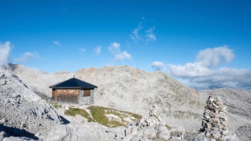 The Wildalmkirchl bivouac, a bivouac hut or bivouac box in the Steinernes Meer, with a large stone