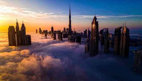 City scape emerging from a dense enveloping fog in sunrise and skyscrapers piercing the haze, big
