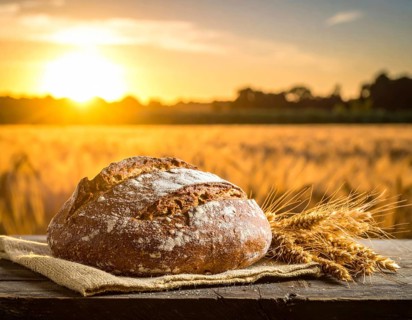 Rustic loaf of whole grain bread, fresh baked, close up of bread on dark wooden table, golden rust,