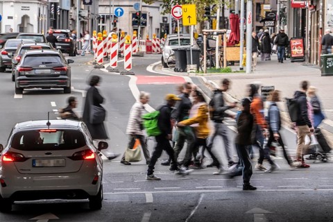 Pedestrians at Düsseldorf-Bilk train station, cross Friedrichstraße at a pedestrian crossing with