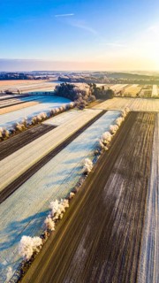 Bird Eye Perspective of Frost Covered Farmland. Seasonal Agricultural Scenery, winter and autumn