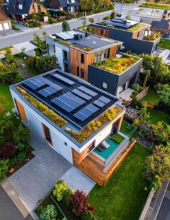 Aerial view showcases modern houses with solar panels and green roofs in a suburban setting,