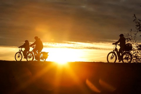 Cyclists ride on a cycle path on the island of Fehmarn at sunset, 13.10.2025, Fehmarn,