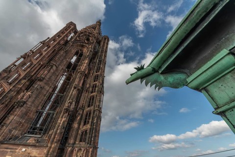 Strasbourg's Gothic cathedral stands majestically under a cloudy sky. In the background is an