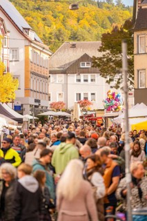Busy shopping street in autumn, people strolling between modern buildings and colorful shops,